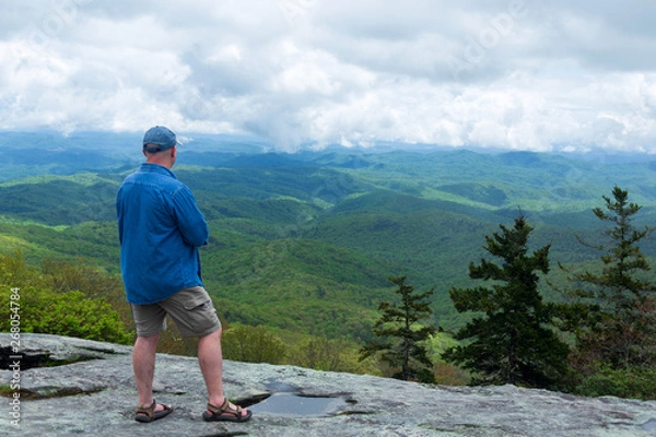 Fototapeta Hiker stops and admires the view at Beacon Heights on the Blue Ridge Parkway in North Carolina.