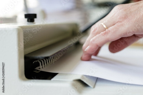 Fototapeta Book Binding Machine Operator. Work with Book binding machine.