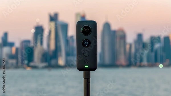 Fototapeta Insta360 One X 360 camera on a tripod with cityscape in the background