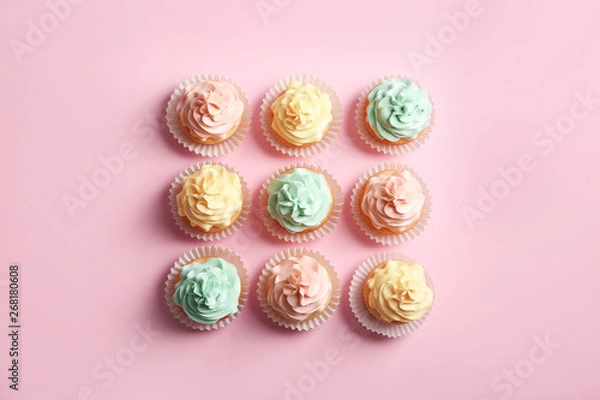Fototapeta Flat lay composition with delicious cupcakes on color background