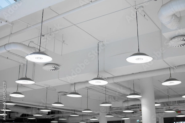 Fototapeta Oświetlenie LED centrum handlowego. Lampy sufitowe w centrum handlowym. Rury wentylacyjne i wodne. System alarmu przeciwpożarowego
