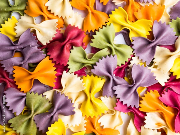 Fototapeta colorful Italian pasta background. Various colors of bow tie farfalle pasta. Top view.