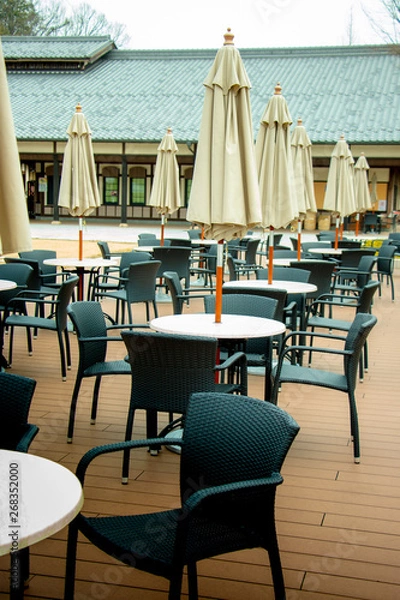Obraz テラス並べられたテーブルセットとパラソル