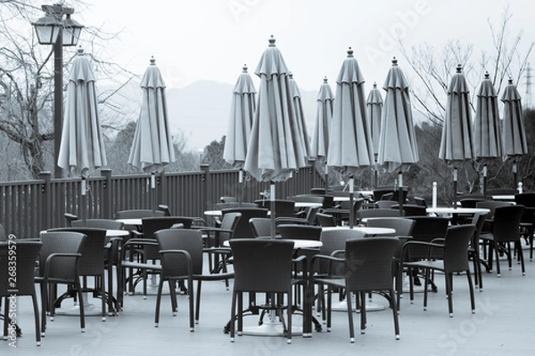 Obraz テラスに並べられたテーブルセットとパラソル