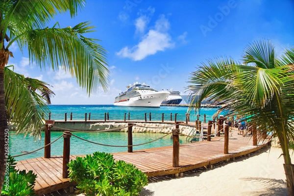 Fototapeta View from beach at tropical resort on cruise ships docked at port 