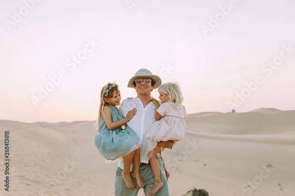 Obraz Happy father holding two daughter in the desert in Dubai