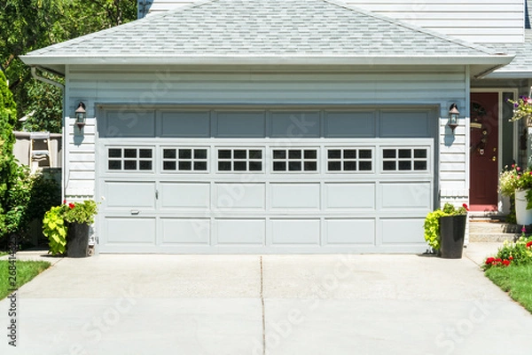 Obraz Wide garage door of residential house and concrete driveway in front