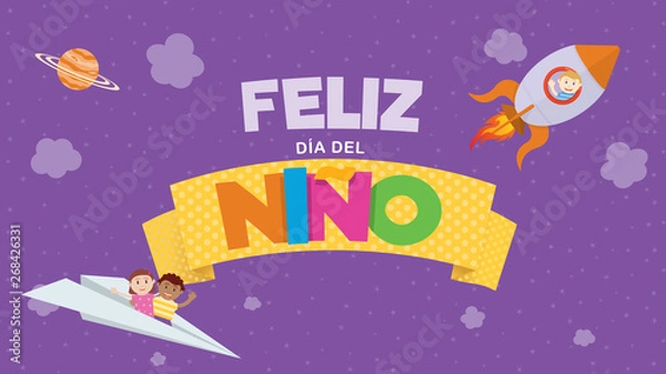 Fototapeta Feliz Dia del Nino greeting card - Happy Children's Day in Spanish language Colored letters on a yellow ribbon with a child flying on a rocket and a couple of children on a paper plane on a purple sky