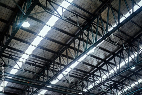 Fototapeta Roof steel beam structure in Industrial factory, Background of factory ceiling with one light blub, Abstract background