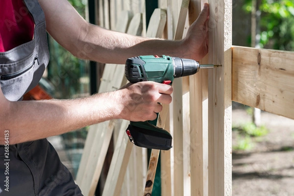 Fototapeta Young man holding drill-drive