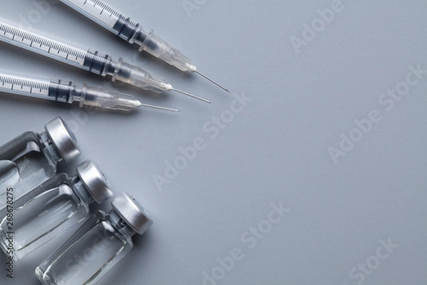 Fototapeta Three syringes with needles and liquid medicine in a small glass bottle