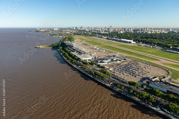 Fototapeta Aerial image showing the full Aeroparque Internacional Ing. Jorge Alejandro Newbery at the river Rio de la Plata with the city of Buenos Aires in the background.