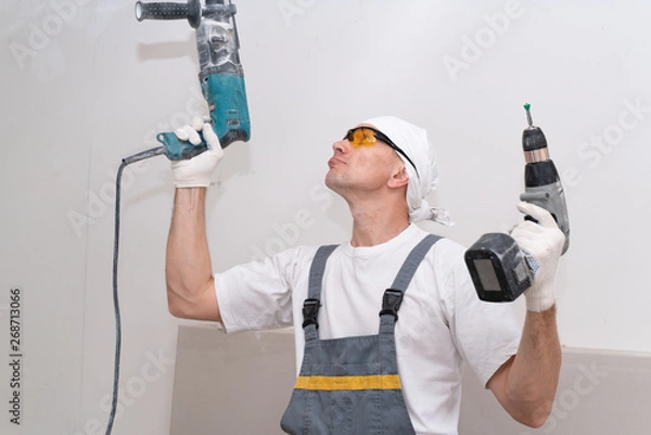 Fototapeta The crazy neighbor drills the ceiling in his apartment with a perforator, in spite of all the neighbors. Breaking the law on silence