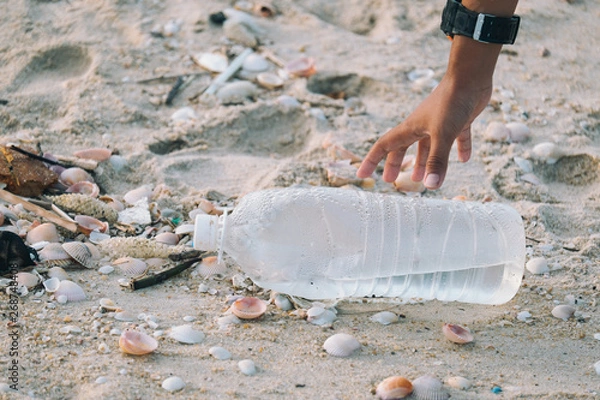 Fototapeta Close-up of arms Children are picking up plastic bottles that are left on the beach. Keep to throw away the trash