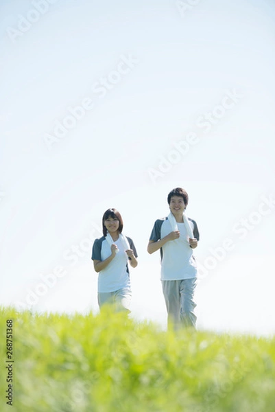 Fototapeta 草原でジョギングをするカップル