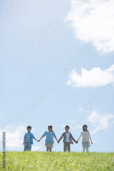 Fototapeta 草原で手をつなぐ小学生
