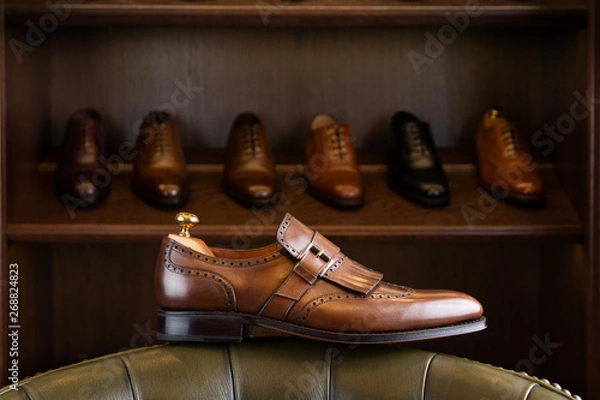 Obraz Brown full grain leather shoe in front of wooden display in men shoes boutique store.