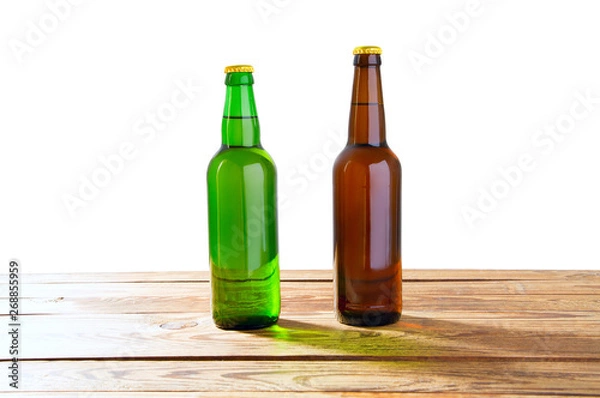 Fototapeta Photo of two different full beer bottles with no labels. Separate clipping path for each bottle included.2 two separate photos merged together. Glass bottles odifferent beer on light white background