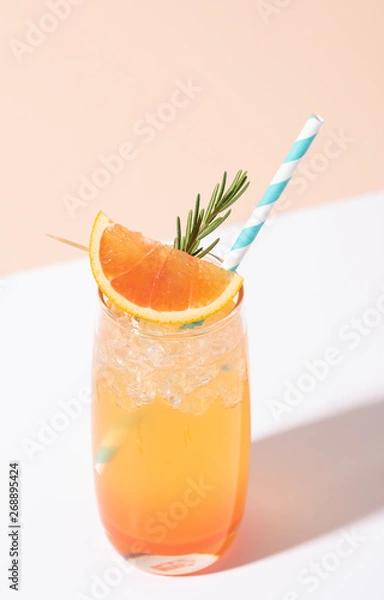 Fototapeta Cold and refreshing orange punch cocktail with orange slice on color background. summer drink.