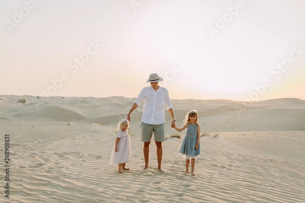 Obraz Young father having fun with his daughters in the desert