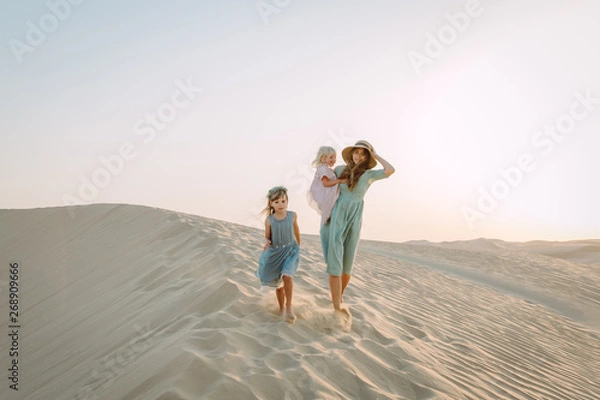 Obraz Young beautiful mother with two little daughters in the desert in Dubai