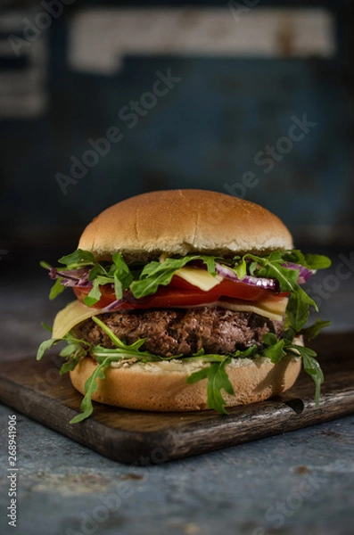 Obraz  Tasty beef burger with vegetables on the table