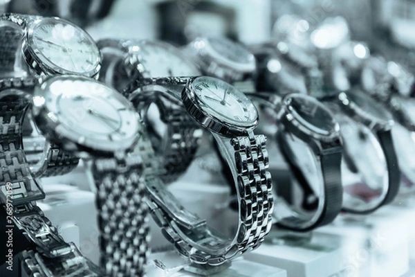 Obraz Abstract watches store with metal bracelet. An expensive new female hand watch on the show case, closeup. Luxury shopping concept.