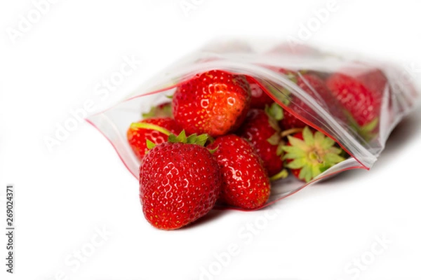 Obraz fresh strawberry in transparent open plastic bag with lock isolated on white.