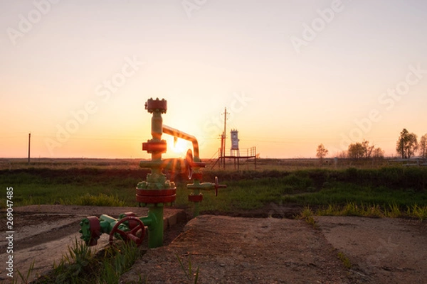 Fototapeta pumping oil and gas from the well. sunset pipes for oil and gas production