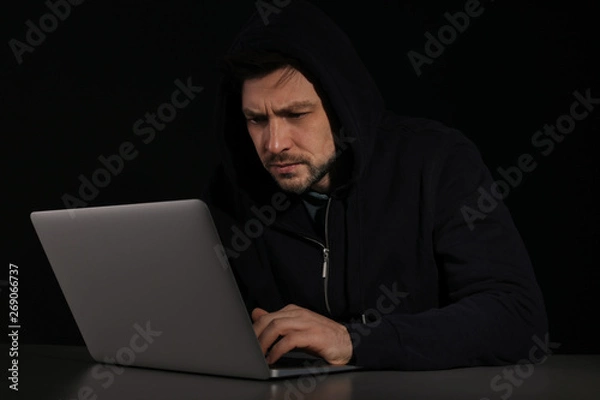 Fototapeta Man using laptop in darkness. Criminal activity