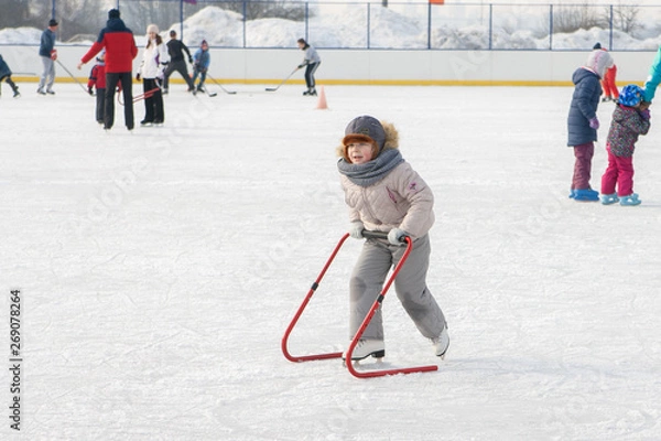 Fototapeta Ice skating with child support device