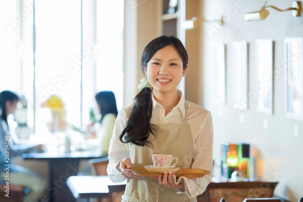 Fototapeta お盆を持ち微笑むカフェの店員