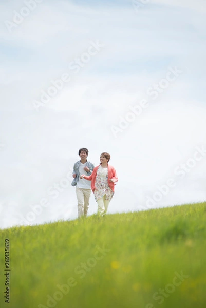 Fototapeta 草原を走るカップル