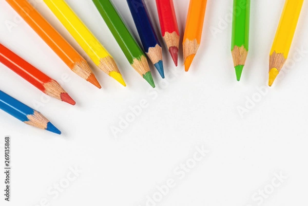 Fototapeta Color pencils for drawing scattered around on a white background. Colors of rainbow.