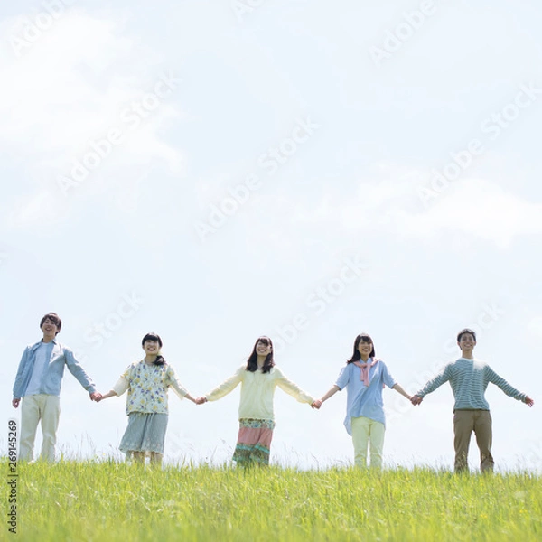 Fototapeta 草原で手をつなぐ大学生