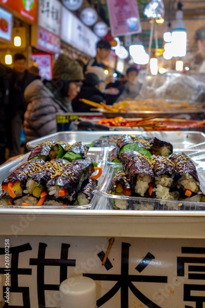 Fototapeta Korean-style gimbap (also known as 'kimbap') sushi rolls for sale among diners at lunch time in the famous, crowded Gwangjang Market in Seoul