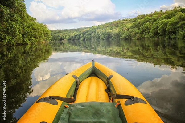 Fototapeta Yellow boat nose  on the still waters of the Danube River.  Mountains and forests frame the background