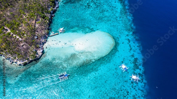 Fototapeta Aerial view of the Sumilon island, sandy beach with tourists swimming in beautiful clear sea water of the Sumilon island beach, Oslob, Cebu, Philippines.