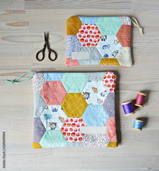 Fototapeta Colorful hexagon quilted pouches, retro scissors and thread on the wooden table