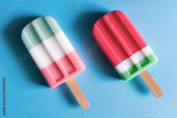 Fototapeta Flat lay of colorful ice cream on the modern rustic on blue background at home office desk wallpaper, top view colorful ice cream pattern on blue pastel background. Minimal summer concept.