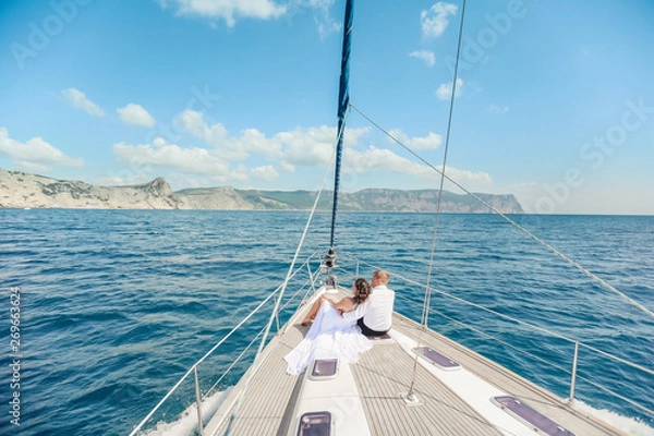 Obraz Young Couple Relaxing on a Yacht. Happy wealthy man and a woman by private boat have sea trip.
