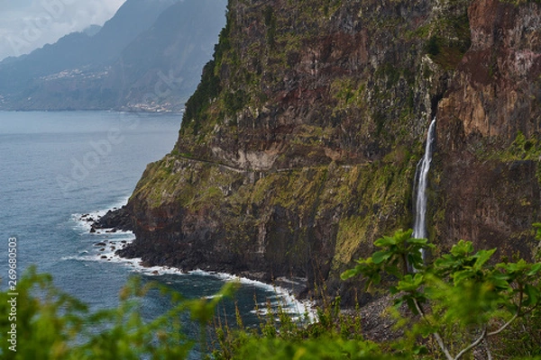 Fototapeta Beautiful view of a waterfall near the blue atlantic ocean and nice sky in Madeira
