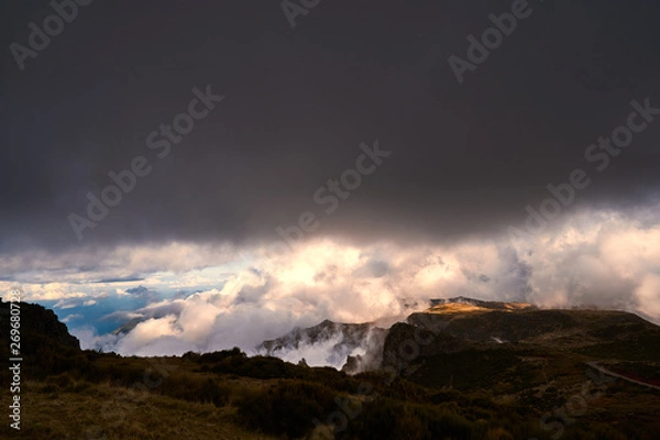 Fototapeta Mountain at sunset with gold clouds and dramatic light in Madeira,pico de arieiro