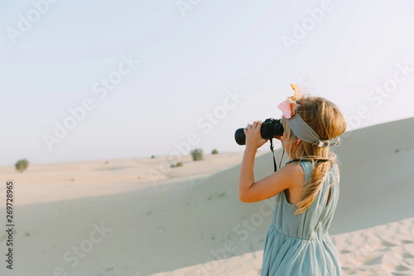 Obraz Little girl watching through the binoculars in the desert