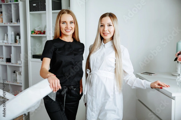 Obraz Two successful confident beauty salon female owners looking at camera. Cheerful female beautician is working with cosmetology. Two women crossed arms with confidence.