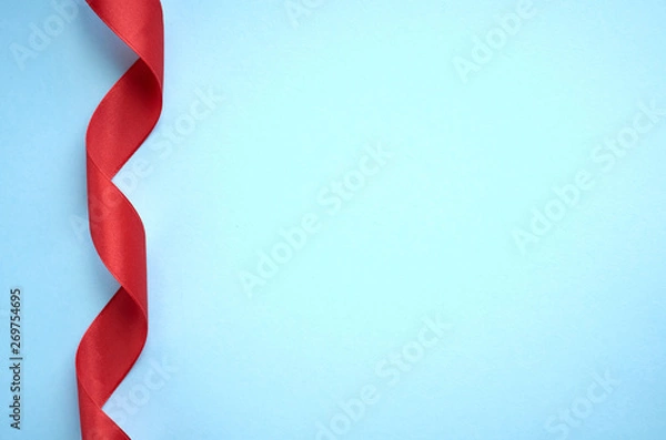 Fototapeta Red ribbon on blue background composition, flat lay