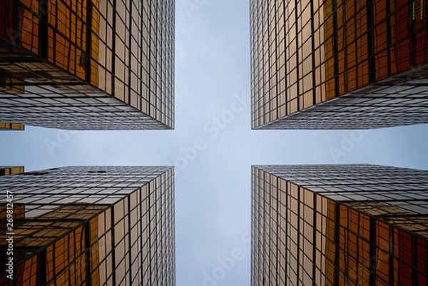 Fototapeta Golden glass building facade in worm eye view in cross view to see the clear sky / abstract architecture / architectural material / background texture
