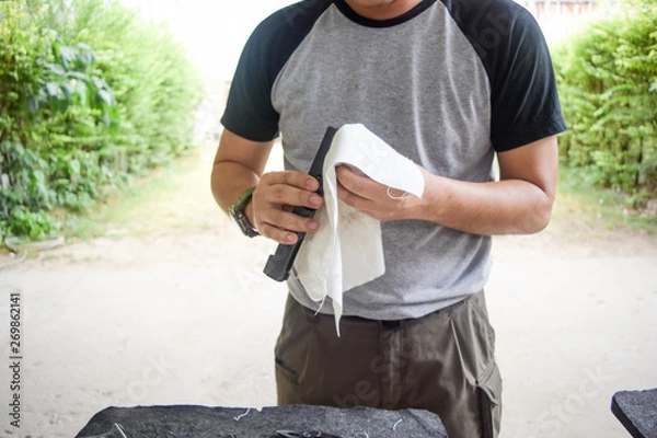 Obraz man cleaning gun