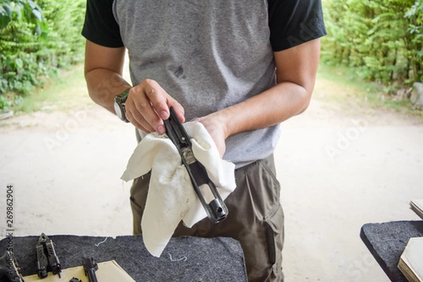 Obraz man cleaning gun