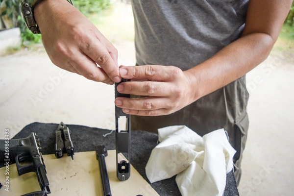Obraz man cleaning gun